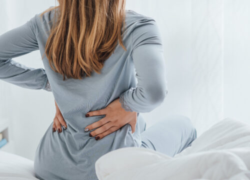 Photo of a woman waking up with back pain
