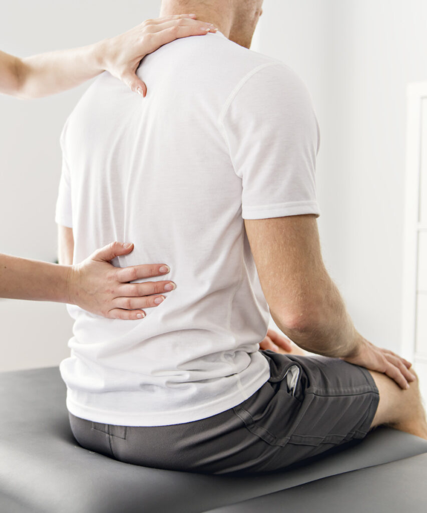 Photo of a man getting his back looked at by a doctor